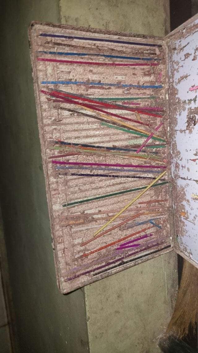 Старый пенал с карандашами после того, как термиты съели дерево