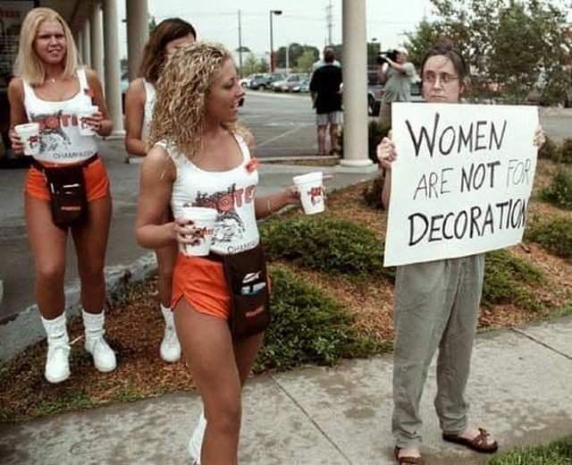 Официантки рeсторана Hooters выносят воду протестующим феминисткам, США, 2000-е