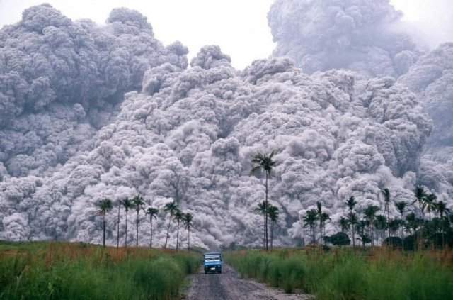 Водитель пикапа пытается сбежать от облака пепла, во время извержения вулкана Пинатубо на Филиппинах. 17 июня 1991 года.