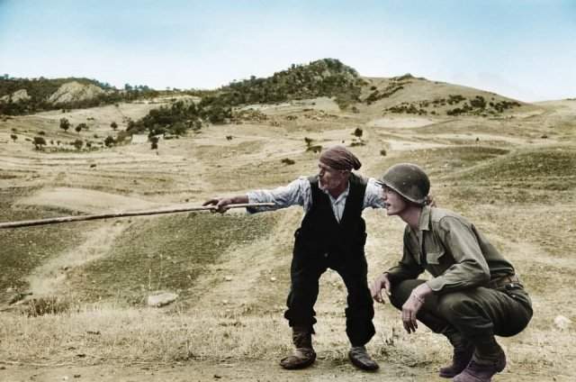 Сицилийский фермер показывает американскому солдату место отступления немцев. Август 1943 года.