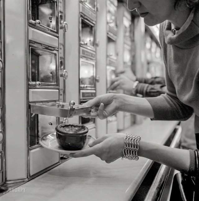 Женщина берет блюдо из запеченных бобов из автомата. Нью-Йорк, июль 1955 года.