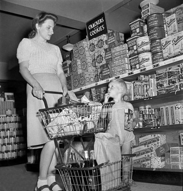 Женщина с сыном покупает продукты в супермаркете. Гринбелт, Мэриленд. Май 1942 года.