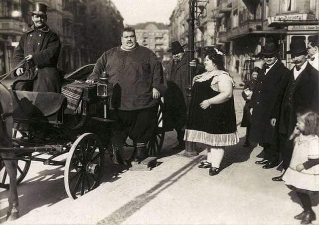 Полный мужчина (вес 284 кг) со своей женой (вес 174 кг) собирается на прогулку в конной коляске. Германия, 1912 год.