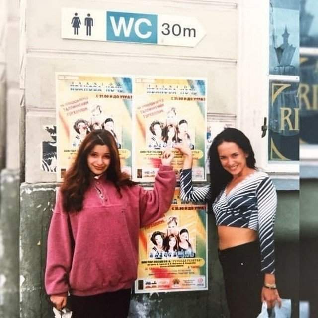 Ольга Орлова и Жанна Фриске на фоне плакатов группы«Блестящие», 1997 год.