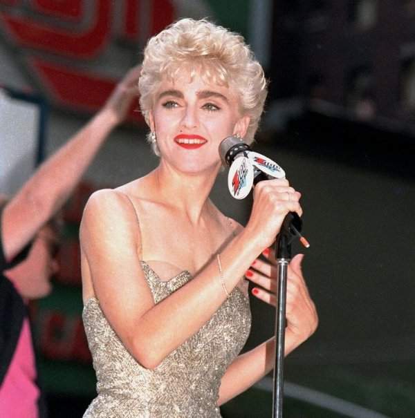 Мадонна приветствует своих поклонников со сцены на Таймс-сквер в Нью-Йорке. 1987 год