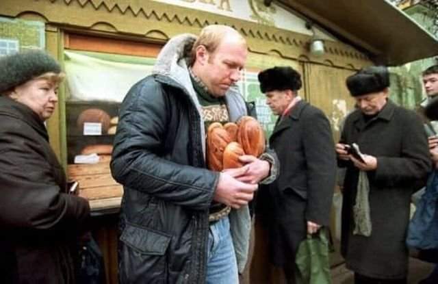 Мужчина уходит от хлебного киоска с несколькими буханками хлеба