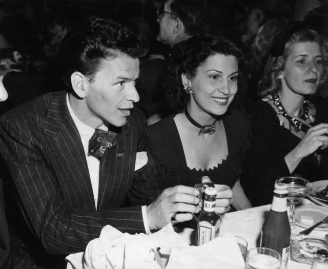 Фрэнк Синатра сидит за столом в ночном клубе рядом со своей первой женой, Нэнси Барбато, 1940 год. Они поженились в 1938 году.