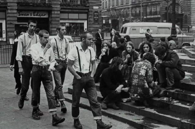 Площадь Пикадилли, Лондон, 1969 год, группа скинхедов проходит мимо группы хиппи