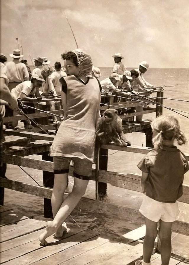 Девушка в купальнике старого образца с обезьянкой на пляже, 1949 год.