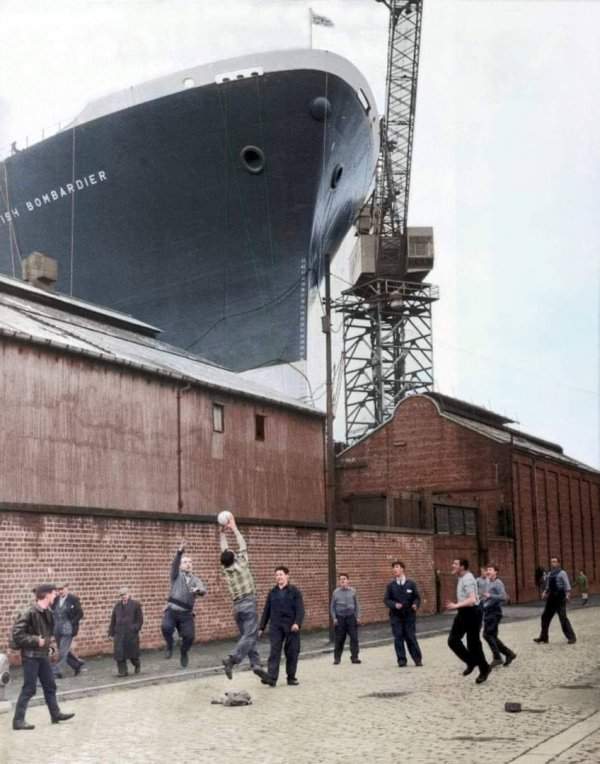Грузовой корабль British Bombardier следит за игрой рабочих в шотландском порту, 1963 год