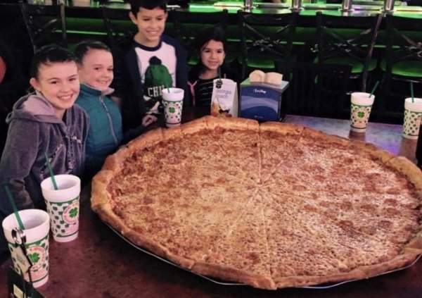Нашёл старое фото, где мы с друзьями позируем с огромной пиццей