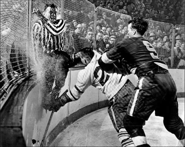 Судья Фрэнк Юдвэри пытается скрыться от столкновения с игроком Торонто, 1956 год.