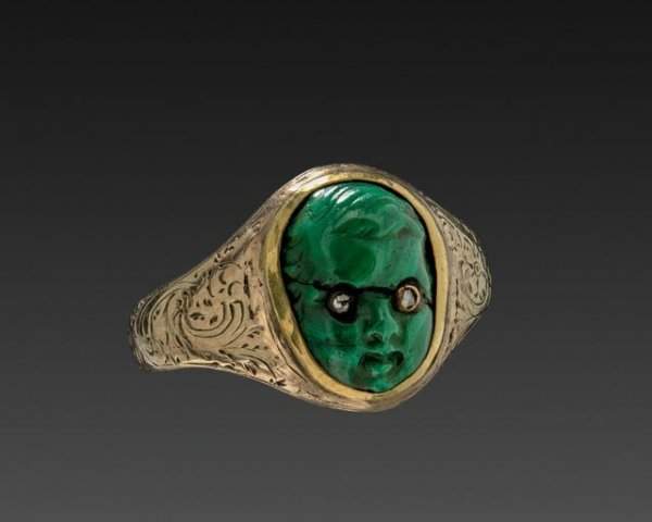 Золотое кольцо с лицом херувима, вырезанное из зелёного камня. Сделано в 19 веке