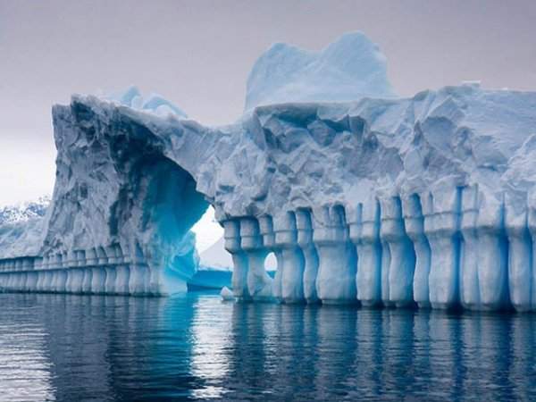 Естественные ледяные образования в Антарктиде, похожие на ледяные стены, колонны и арку