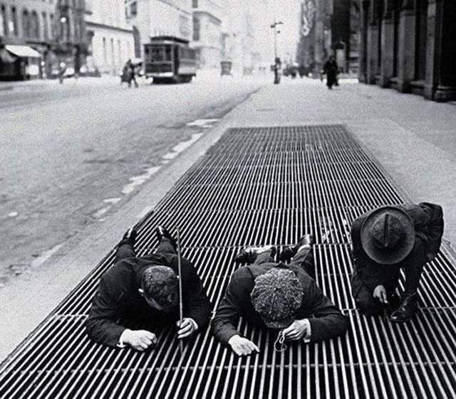 Мальчишки вылавливают мелкие монетки из вентиляционной решетки в Нью-Йорке во время Великой Депрессии, 1930 г.