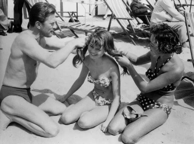 Кирк Дуглас заплетает косы Бриджит Бардо на Каннском кинофестивале в 1953 году