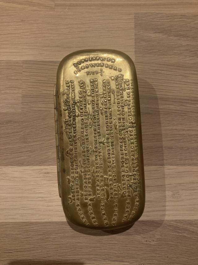 Золотая коробка 1787 года с месяцами по обеим сторонам, за которыми следует ряд букв и цифр. Найдена на чердаке