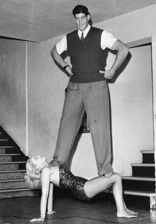 Мужчина стоит на силовой актрисе цирка Джоан Роудс, 1955 год.