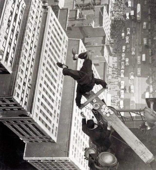 Акробат балансирует на доске на краю крыши небоскреба, США, 1939 год.
