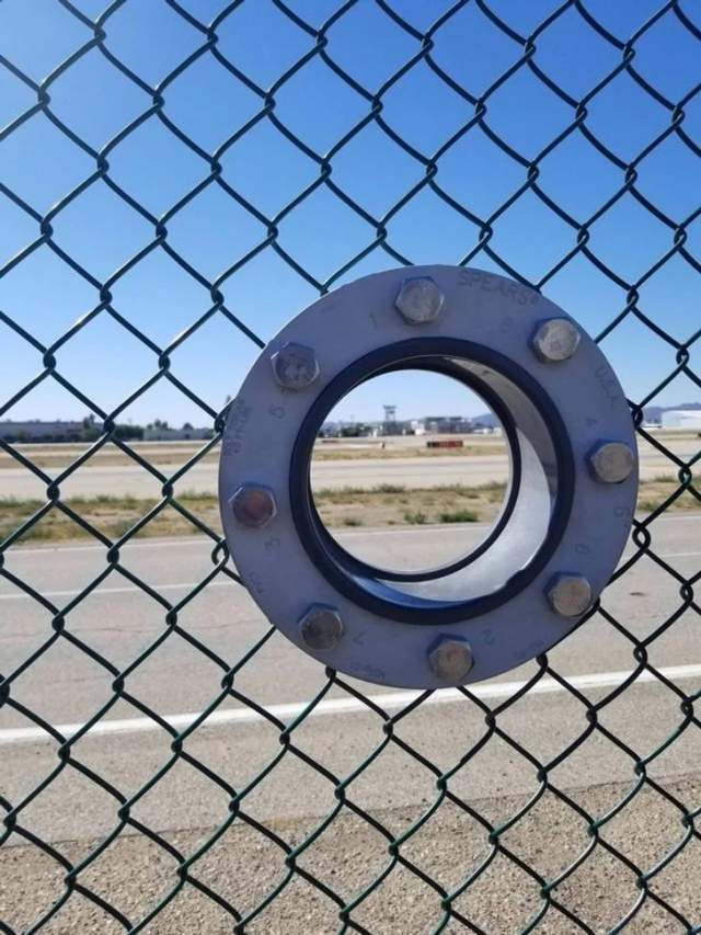В сетчатом ограждении аэропорта есть специальное отверстие для объективов фотоаппаратов