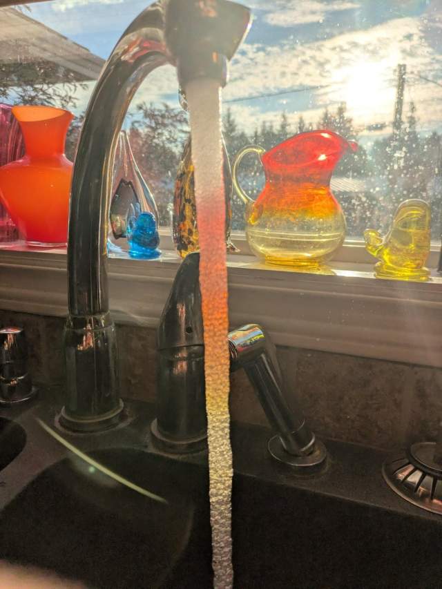 Солнечный свет проникает сквозь кувшин, и вода кажется разноцветной